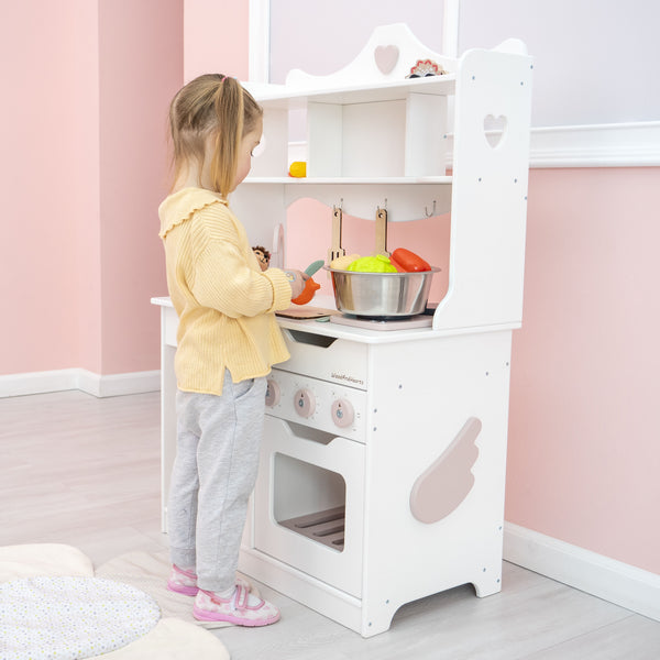 Mädchen Spielzeugküche für Kleinkinder tun vor, dass sie in Weiß + rosa Farben spielen