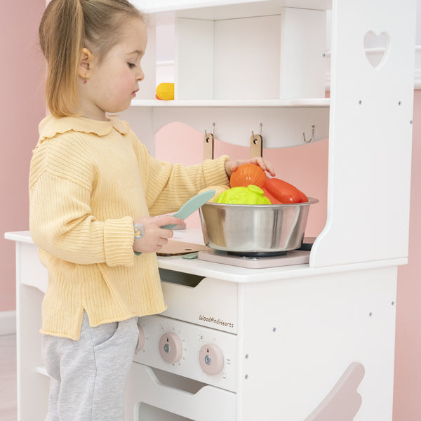 Mädchen Spielzeugküche für Kleinkinder tun vor, dass sie in Weiß + rosa Farben spielen